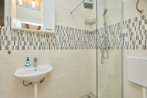 a white bathroom with a sink and a shower at Santa Barbara Mljet apartment in Babino Polje