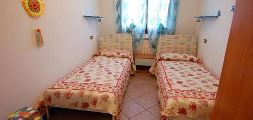 a room with two beds in a room with a window at Ville Timoniere 6B in Isola Albarella