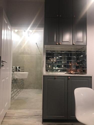 eine Küche mit schwarzen Schränken und einem Waschbecken in der Unterkunft Luxury Wola Apartament in Warschau