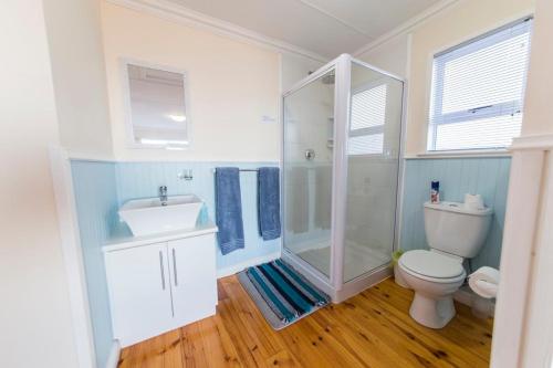 uma casa de banho com um chuveiro, um WC e um lavatório. em Casa Surf Lodge J'Bay em Jeffreys Bay