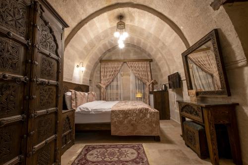 a bedroom with a bed in a stone room at Underground Cave Suites Hotel in Goreme