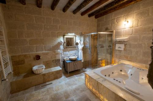 a large bathroom with a tub and a shower at Underground Cave Suites Hotel in Goreme