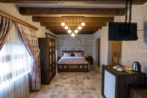 a bedroom with a bed and a television in it at Underground Cave Suites Hotel in Goreme