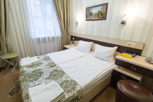 a hotel room with a bed and a chair at Hotel Voyage in Kharkiv
