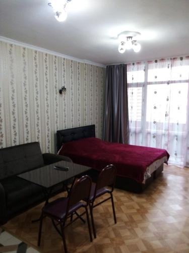 a bedroom with a bed and a table and chairs at kvartira 120 m do pliaj in Batumi