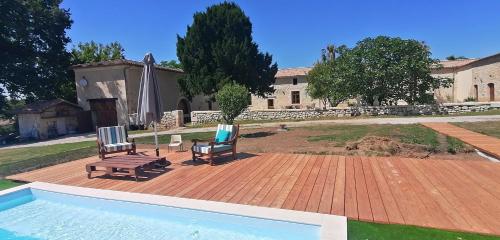 a patio with two chairs and a table and a pool at Domaine de Gaïa, Piscine, Pétanque, Ping-pong, proche Saint Emilion in Guillac