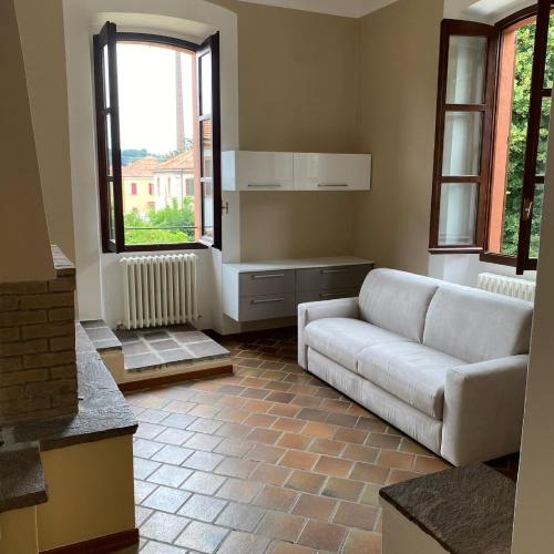 a living room with a couch and two windows at Crespi d'Adda a "colori" in Capriate San Gervasio