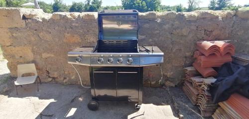 a stove top oven sitting next to a stone wall at Domaine de Gaïa, Piscine, Pétanque, Ping-pong, proche Saint Emilion in Guillac