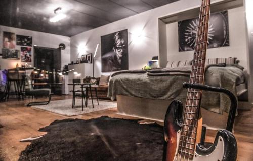 a bedroom with a guitar sitting next to a bed at Backstage in Haacht