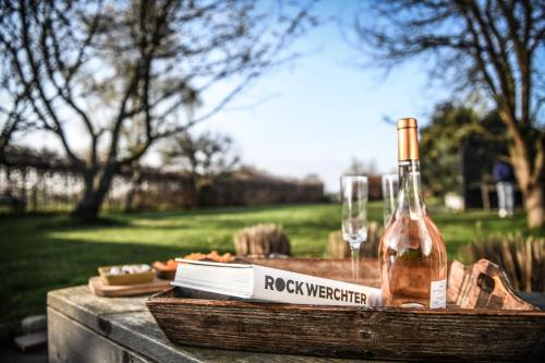 una bottiglia di vino e bicchieri su un tavolo di legno di Backstage a Haacht