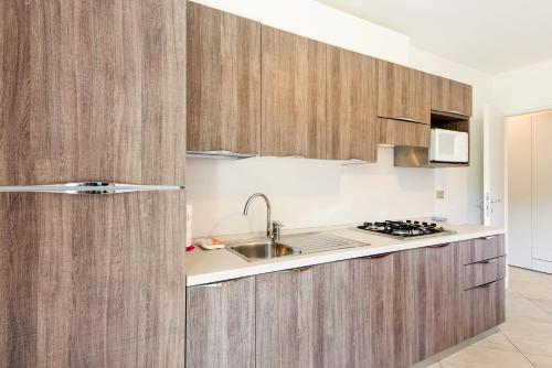 a kitchen with wooden cabinets and a sink at Casa Alberta in Pieve Di Ledro