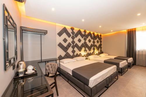 a bedroom with two beds and a desk and a window at White Palace Hotel in Istanbul