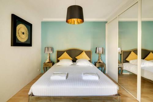 une chambre avec un grand lit blanc et un miroir dans l'établissement C059-Splendid apartment with air conditioned - Cannes, à Cannes