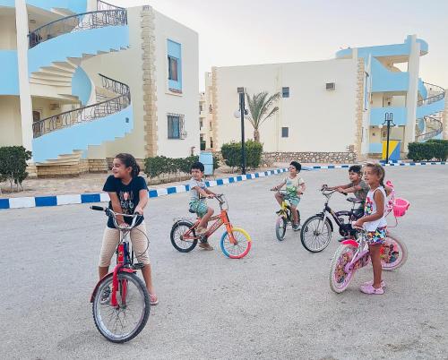 un grupo de niños montando bicicletas en la calle en Golden Beach 1 Ras Sedr en Ras Sedr