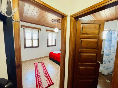 a room with a door and a bed in a room at Denis GuestHouse 1930 in Gjirokastër