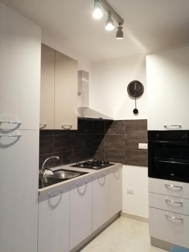 a white kitchen with a sink and a stove at Blu Home in Crotone