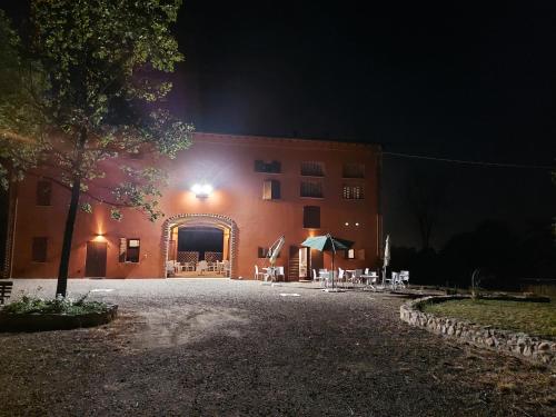a building at night with a table and chairs at AGRITURISMO AZIENDA AGRICOLA FERRARI M.RITA in Pozza