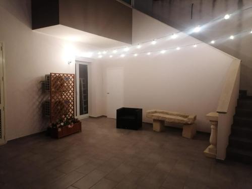 a room with a staircase and a bench and lights at Dimora Felline in Giurdignano