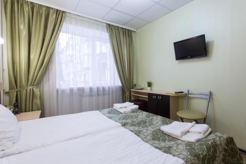 a hotel room with a bed and a television at Hotel Voyage in Kharkiv