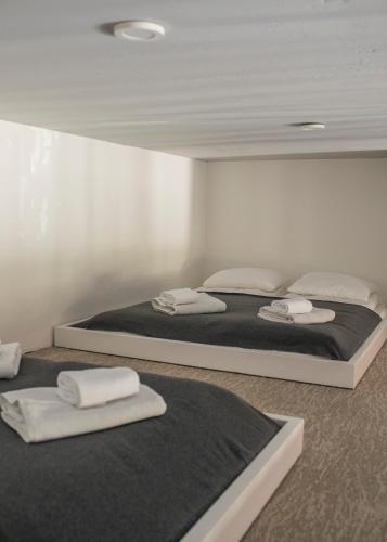 two beds in a room with towels on them at Alyvų Namai Nida in Nida