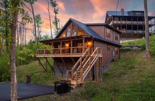 a house on a hill with a deck and a building at Creekside Manor Too cabin in Gatlinburg