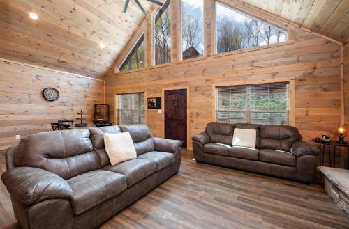a living room with two leather couches in a cabin at Creekside Manor Too cabin in Gatlinburg