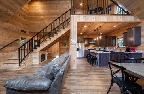 a large living room with a couch and a staircase at Creekside Manor Too cabin in Gatlinburg