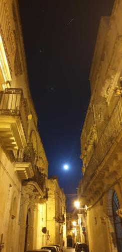 a city street at night with a moon in the sky at Giulia's House in Galatina