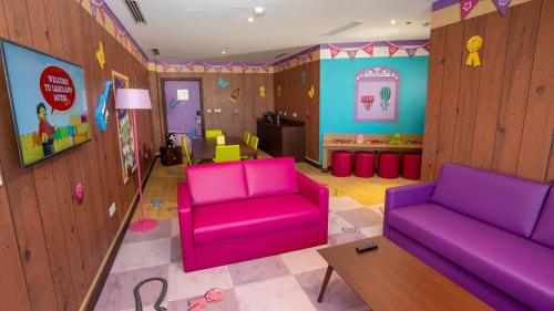 a living room with two purple chairs and a table at LEGOLAND Hotel Dubai in Dubai