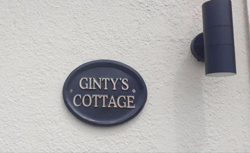 een bord aan de zijkant van een gebouw bij Cozy & Remote Hideaway Gintys Cottage in Ross Port