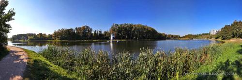 a large lake in a park on a sunny day at Family & Business Sauna Apartments Klonowa nad Zalewem, Unikat SPA - 2 Bedroom with Private Sauna, Jacuzzi, Air Conditioning, Garage - The Highest Standard! in Kielce