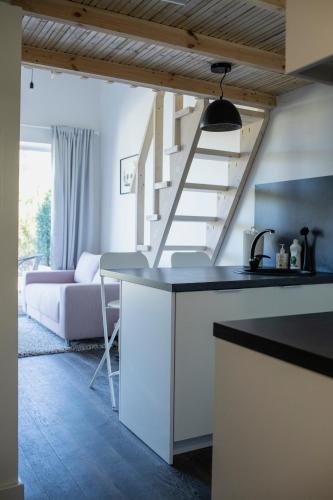 a kitchen with a counter top and a staircase at Alyvų Namai Nida in Nida