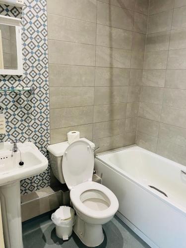 a bathroom with a toilet and a tub and a sink at Farnley Tower Guesthouse in Durham