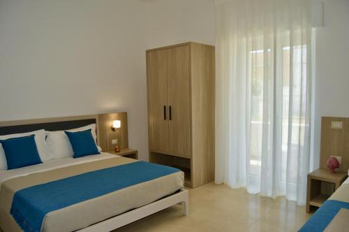 Un dormitorio con una cama grande con almohadas azules. en B&B MarAlè, en Porto Cesareo