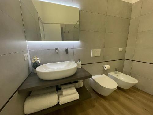 a bathroom with a sink and a toilet and a mirror at Admayora Guest House in Villasimius