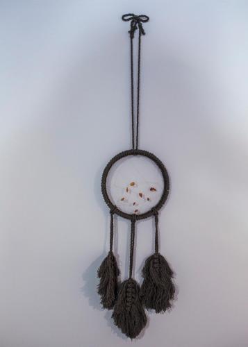 a dream catcher hanging on a white wall at Alyvų Namai Nida in Nida