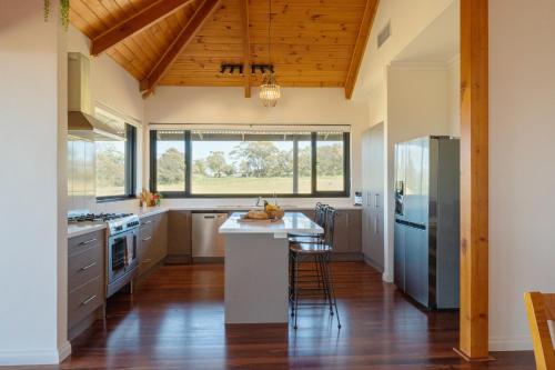 a kitchen with wooden ceilings and a wooden floor at Old Coach Road Estate in Hindmarsh Valley