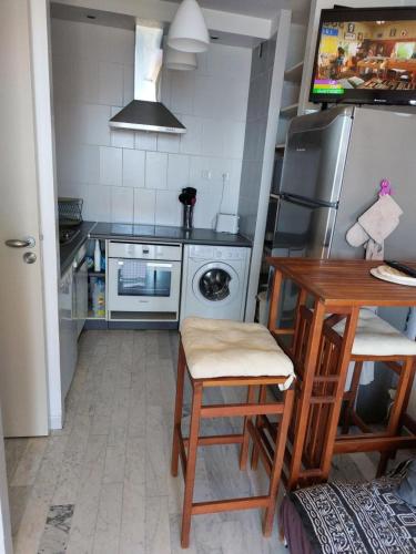 une cuisine avec une table et un réfrigérateur dans l'établissement AJACCIO SANGUINAIRES APPT 3 P POUR 4 A 5 PERSONNES TTES COMMODITÉS TT CONFORT ! A 300M DES PLAGES ET A 5 MN DU CENTRE VILLE, à Ajaccio