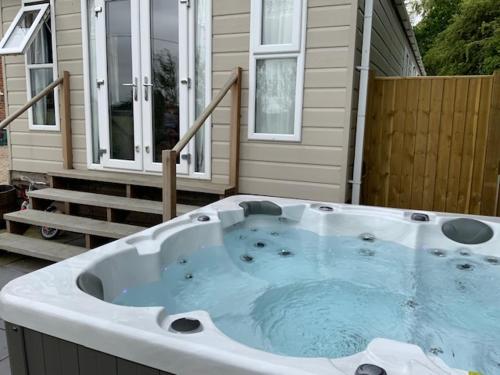 a hot tub in front of a house at Molland Manor House Bed & Breakfast in Sandwich