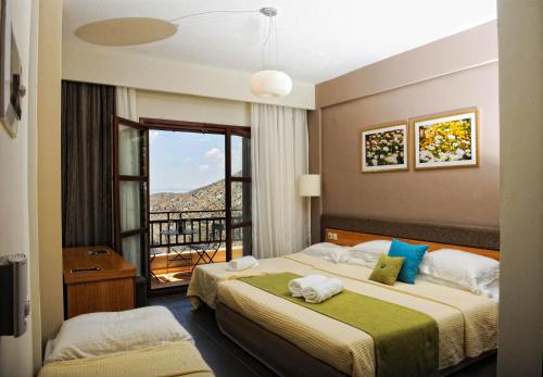 En eller flere senge i et værelse på Pilion Terra Hotel