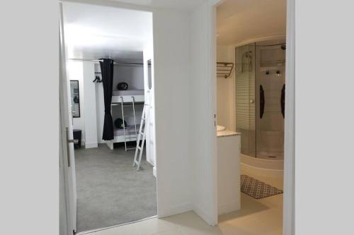 a white bathroom with a shower and a mirror at Une - Halte Entre Les Ponts - en toute simplicité in Saumur