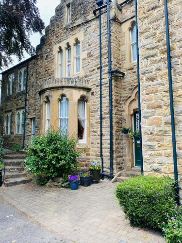 an old stone building with plants in front of it at Farnley Tower Guesthouse in Durham