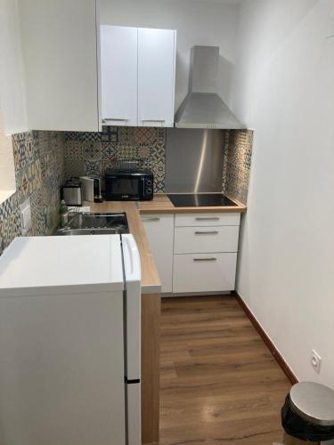 a kitchen with white cabinets and a counter top at Charmant T2 au coeur de la rue Fesch in Ajaccio