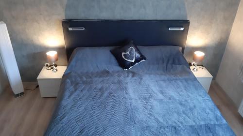 a blue bed with a black pillow on top of it at Ferienwohnung Am Ostfriesland-Wanderweg in Rhauderfehn