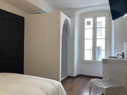 een slaapkamer met een bed, een wastafel en een raam bij Charmant T2 au coeur de la rue Fesch in Ajaccio