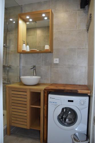 a bathroom with a washing machine and a sink at Appartement Studio rénové le Corbier 4 personnes 22m2 domaine les Sybelles Classé 2 étoiles label qualité le corbier in Villarembert
