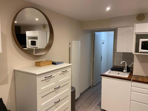 - une cuisine avec des placards blancs et un miroir dans l'établissement Appartement Studio rénové le Corbier 4 personnes 22m2 domaine les Sybelles Classé 2 étoiles label qualité le corbier, à Villarembert