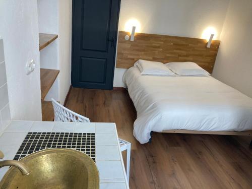 a bedroom with a bed and a table and a chair at Charmant T2 au coeur de la rue Fesch in Ajaccio