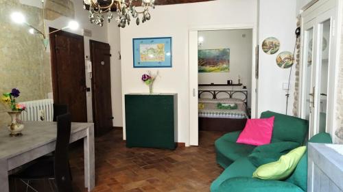 un soggiorno con divano verde e tavolo di Non ditelo al Duca - Belvedere Sant'Angelo a Spoleto