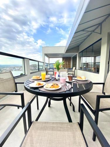 a table with plates of food on a balcony at Pousada Belvedere in Capitólio